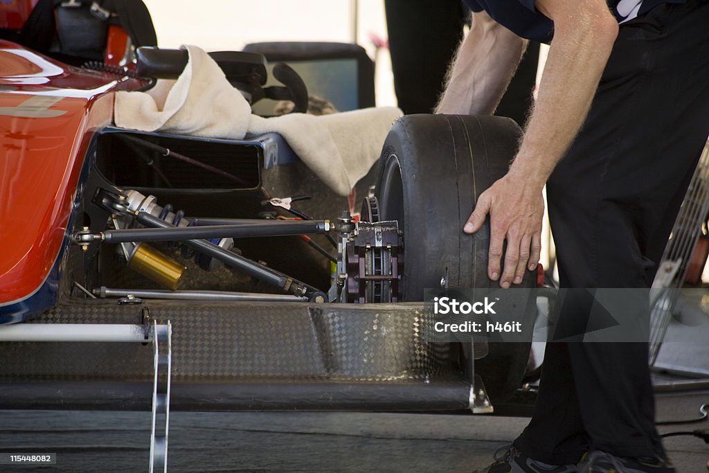 Race car preparation Mechanic putting on tire on race car preparation. Racecar Stock Photo