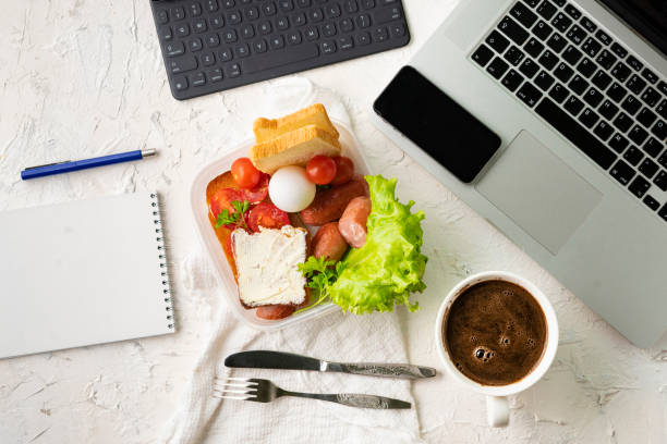 istock top view of the office work place with computer or laptop pen and phone, nutritious lunch during the works 1154482193