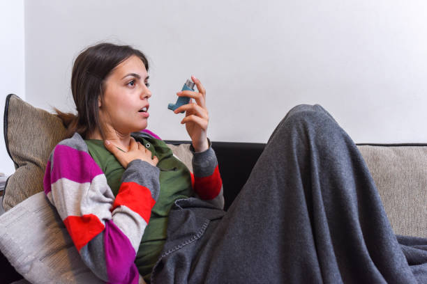 Young woman using an asthma inhaler