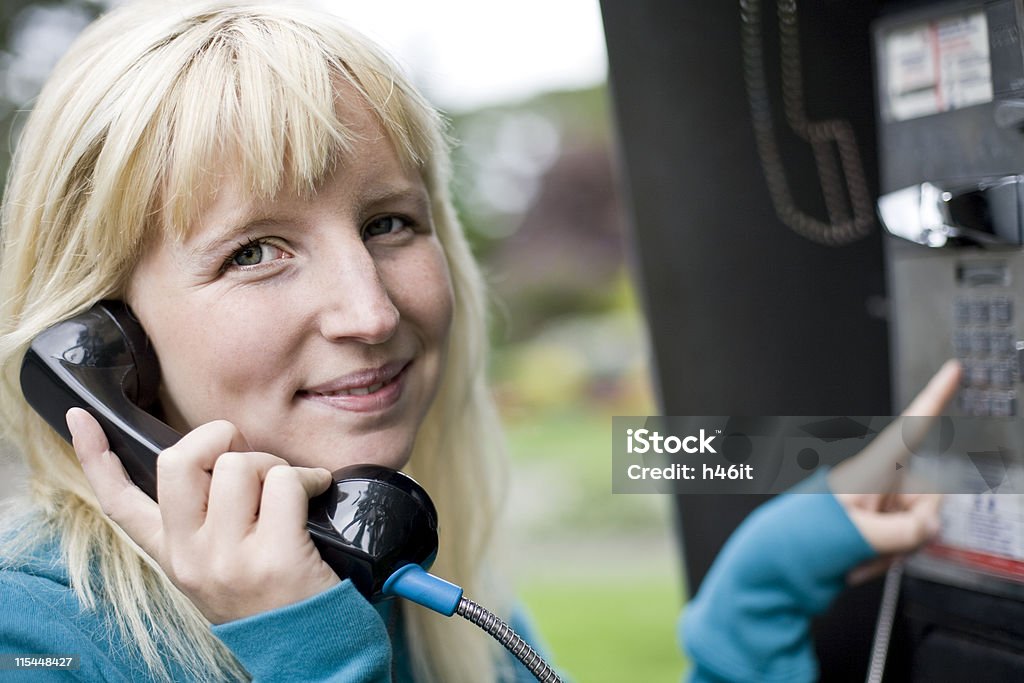 Dziewczyna za pomocą telefonu publicznego - Zbiór zdjęć royalty-free (Automat telefoniczny)