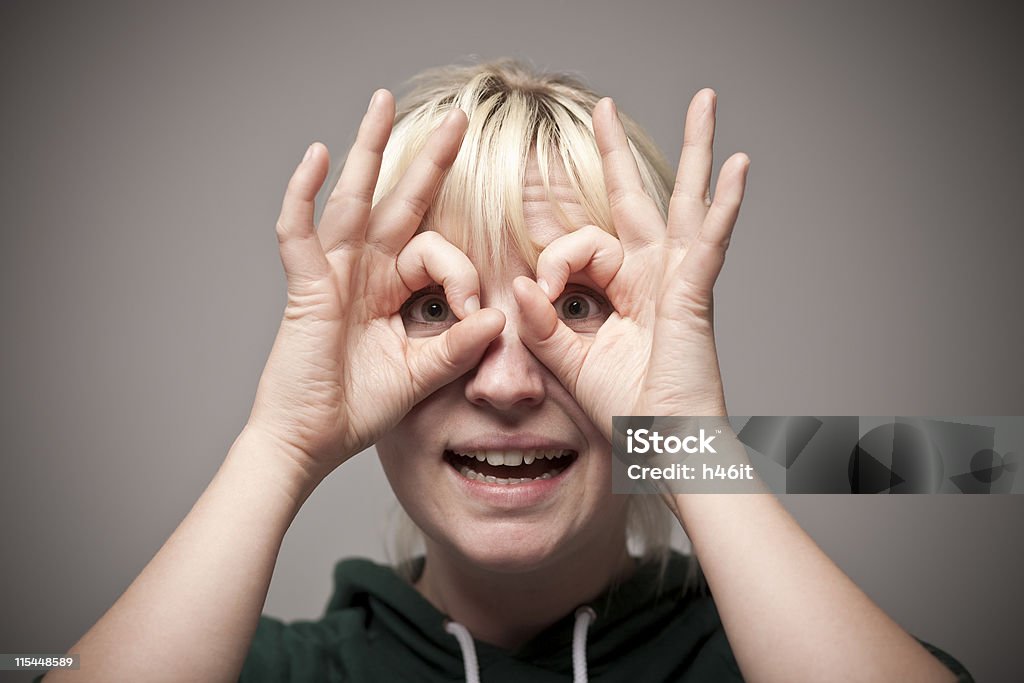 Finger Glasses Girl uses hands and fingers to make viewing glasses Adult Stock Photo