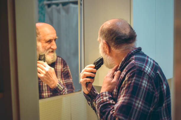 istock Senior male starts cutting his beard off with trimmer 1154486302
