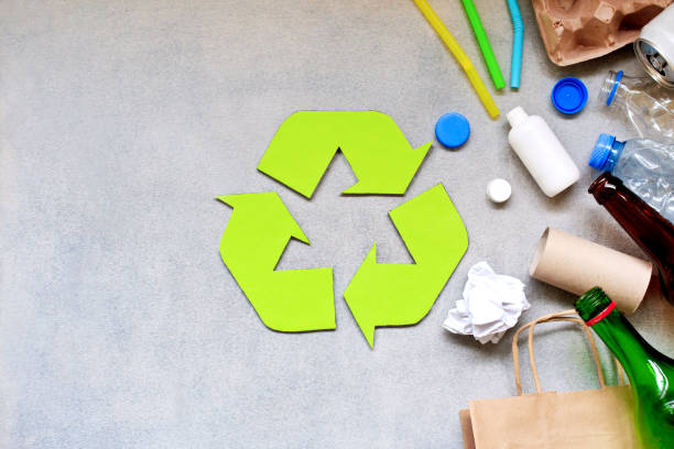 istock Recycling symbol and different garbage on gray background. Top view. 1154488064