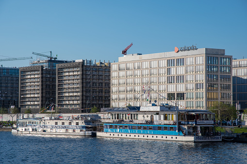 Berlin Germany - April 21. 2018: Hotel Barges on river Spree in front of modern office buildings and the Berlin Wall