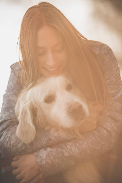 istock Happy woman hugging a golden retriever 1154491699