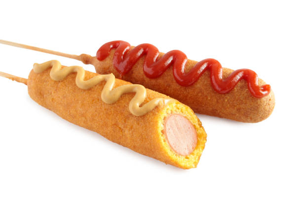 los perros de maíz con ketchup y mostaza sobre fondo blanco - corn dog fotografías e imágenes de stock