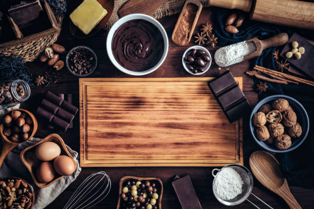 fare mousse al cioccolato e ingredienti intorno a una cornice di tagliere su una cucina rustica tavolo di legno - baking flour ingredient animal egg foto e immagini stock