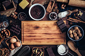 Making chocolate mousse and ingredients around a cutting board frame on a wooden table rustic kitchen
