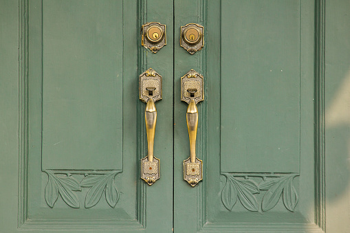 Door Handles Old brass on the green door Used to close or open the door