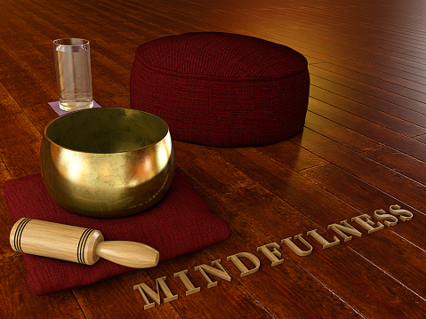 Mindfulness - Meditation environment with wooden floor, Tibetan singing bowl, glass of water, Cushion Zafu Yoga Meditation and the word mindulness in wood - 3D illustration