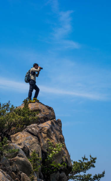 istock A photographer takes a picture on a rock 1154515908