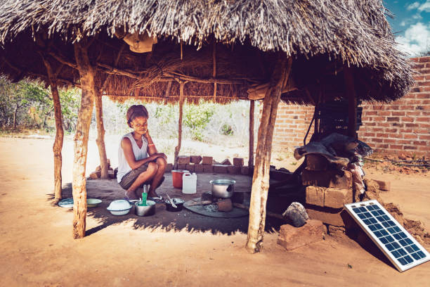 아프리카 마을의 오두막 아래에서 옥수수 미로를 요리 하는 젊은 여자 - rural africa 뉴스 사진 이미지