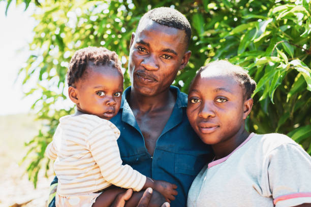 jeune couple de village avec leur bébé fille - africa child village smiling photos et images de collection