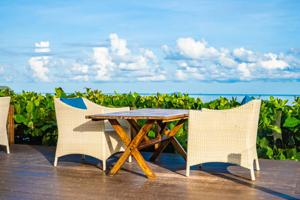 istock Empty table and chair for dining set nearly sea ocean beach on white cloud blue sky 1154527766