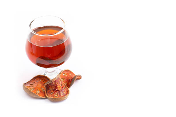 istock Bael fruit tea - A glass of Bael fruit tea and dried fruit Bale beverage On a white background 1154528148
