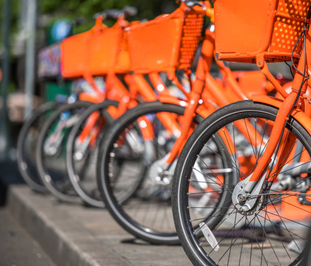 istock Orange bikes for public rentals stand in line waiting for cyclists 1154532812