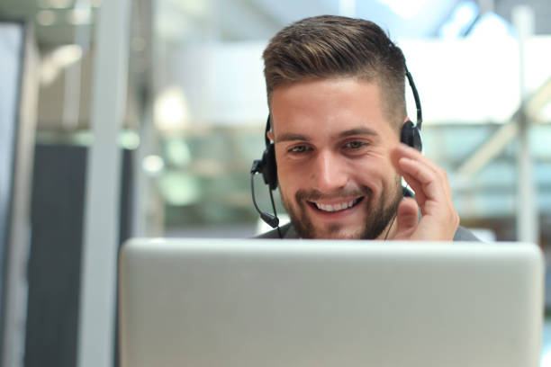 istock Smiling friendly handsome young male call center operator. 1154533201