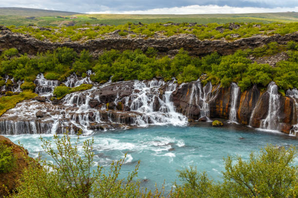 Hraunfossar waterfall powerful streams falling into Hvita river turquoise waters, Husafell, Western Iceland Hraunfossar waterfall powerful streams falling into Hvita river turquoise waters, Husafell, Western Iceland hraunfossar stock pictures, royalty-free photos & images