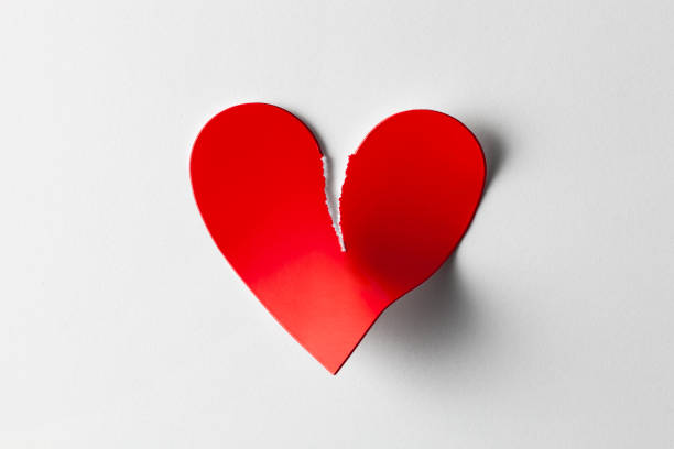 istock Broken heart. Red torn paper heart on white background. 1154536859