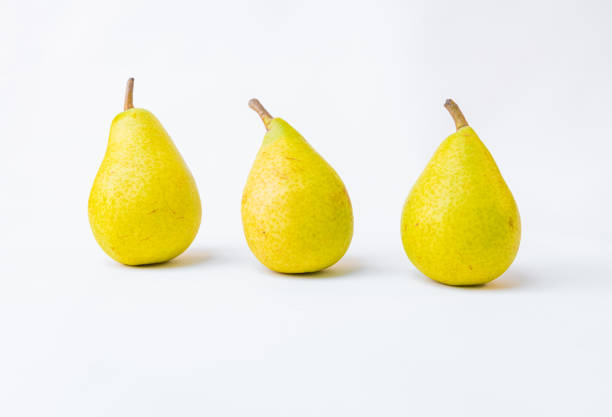 Bio pears lined up. Geometric composition of yellow pears on white background