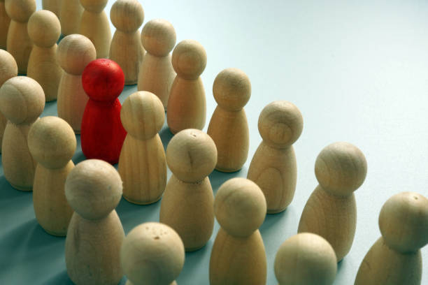istock Uniqueness concept. One unique figurine in the crowd. 1154537178