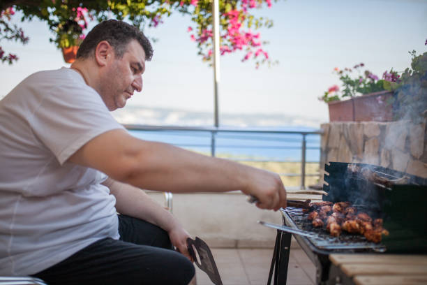 istock Man cooking meat on bbq 1154539686