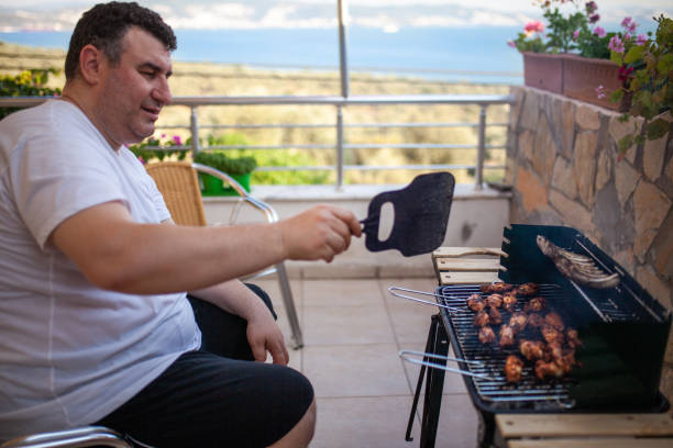 istock Man cooking meat on bbq 1154539696