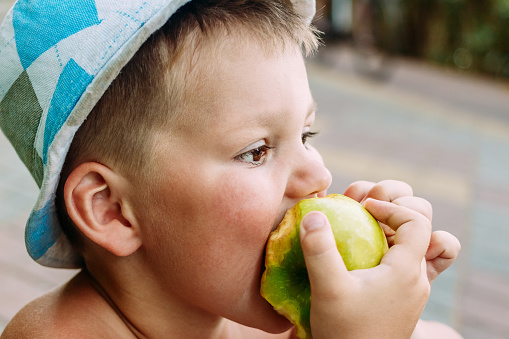 a child bitten by a Green Apple. to eat an Apple