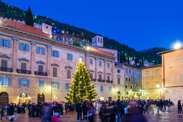 People around the Christmas tree celebrate the religious festivity in Piazza Grande in Gubbio, a town of very ancient origins located in Umbria, central Italy.
