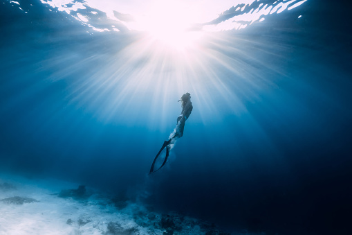 Mujer freediver se desliza sobre el mar arenoso con aletas photo