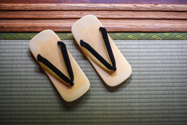High angle view of traditional Japanese geta sandals resting on tatami mat for guest use at Tokyo ryokan.