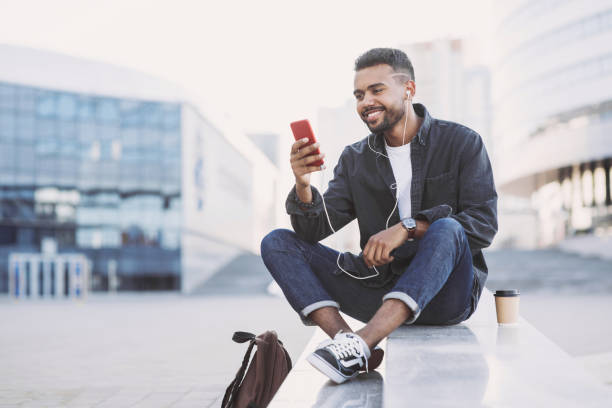 istock Cheerful young man using smart phone in a city 1154550592