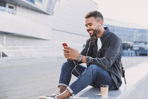 istock Cheerful young man using smart phone in a city 1154550593