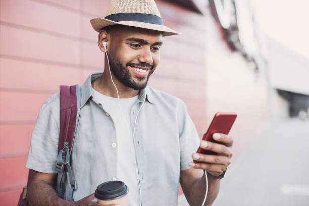 istock Cheerful young man traveler using smart phone in a city 1154550674