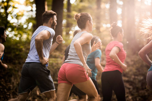 istock Back view of marathon runners racing through the forest. 1154556122