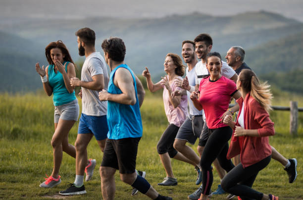 istock Group of happy mixed age people having fun while jogging in nature. 1154556917