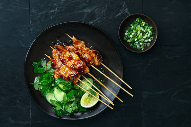Japanese chicken yakitori skewers Japanese chicken yakitori skewers with vegetables salad on dark background skewer photos stock pictures, royalty-free photos & images
