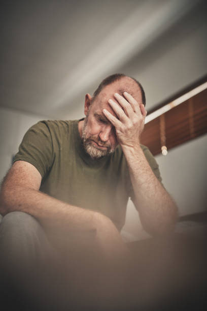 istock Stressed or depressed middle-aged man bows his head in despair 1154560560