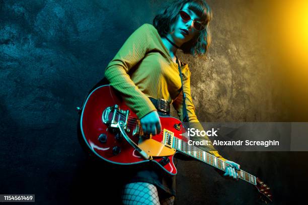 Charming Hipster Woman With Curly Hair With Red Guitar In Neon Lights Rock  Musician Is Playing Electrical Guitar 90s Style Concept Stock Photo -  Download Image Now - iStock