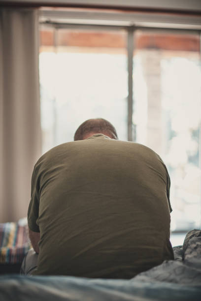 Stressed or depressed middle-aged man bows his head in despair Unhappy man considers his miserable life. divorcee stock pictures, royalty-free photos & images