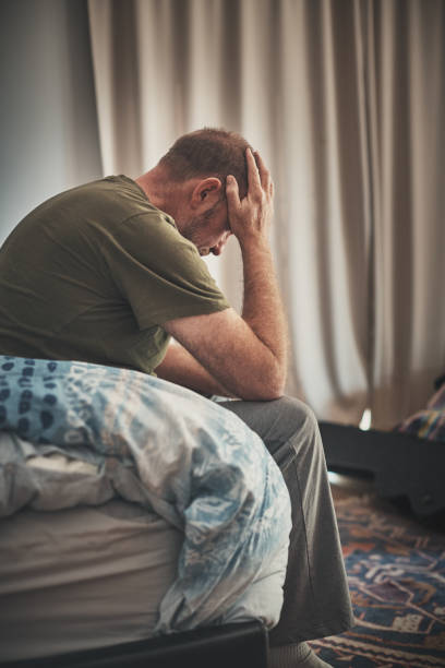 Stressed or depressed middle-aged man bows his head in despair Unhappy man considers his miserable life. divorcee stock pictures, royalty-free photos & images