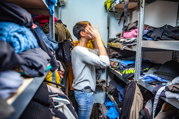 madre confundida buscando ropa. - desbordar fotografías e imágenes de stock