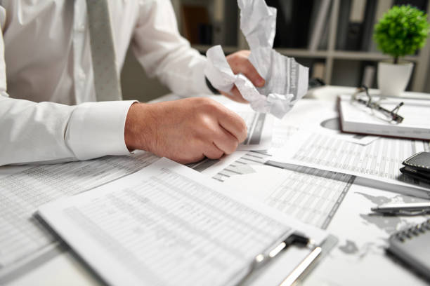 istock Angry businessman has stress and troubles with bad reports, he breaks documents and throws it. 1154565097