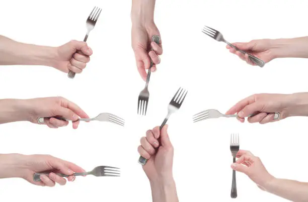 Photo of hand holding a silver fork on an isolated white background. Multiple image.
