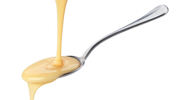 istock Pouring condensed milk isolated on white background 1154567842