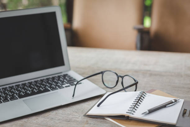 istock Laptop, Pen, notebook and glasses on the wooden table 1154568334