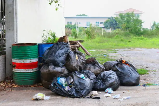 Photo of Pollution Bin Garbage, Bin bag black Trash beside the fence home office on street, 3R