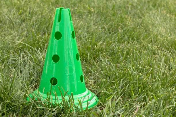 istock Bright green plastic sports cone on the green grass. 1154569471