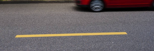 istock car on an asphalt road and a yellow horizontal line. 1154570510