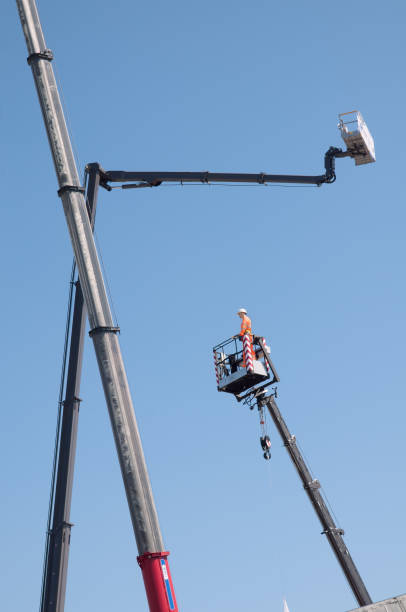 istock Electrician dummy in basket on cherry picker on blue sky background. 1154572091
